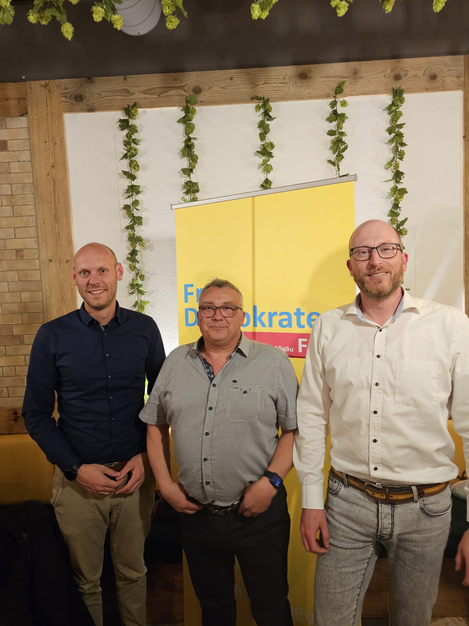 Daniel Derscheid, Alexander Ort und Sebastian Scherer (von links nach rechts) stehen vor einem FDP Banner.